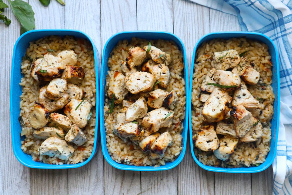 herbs de provence chicken on top of rice in meal prep containers 