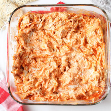 glass container of creamy buffalo chicken dip with chips