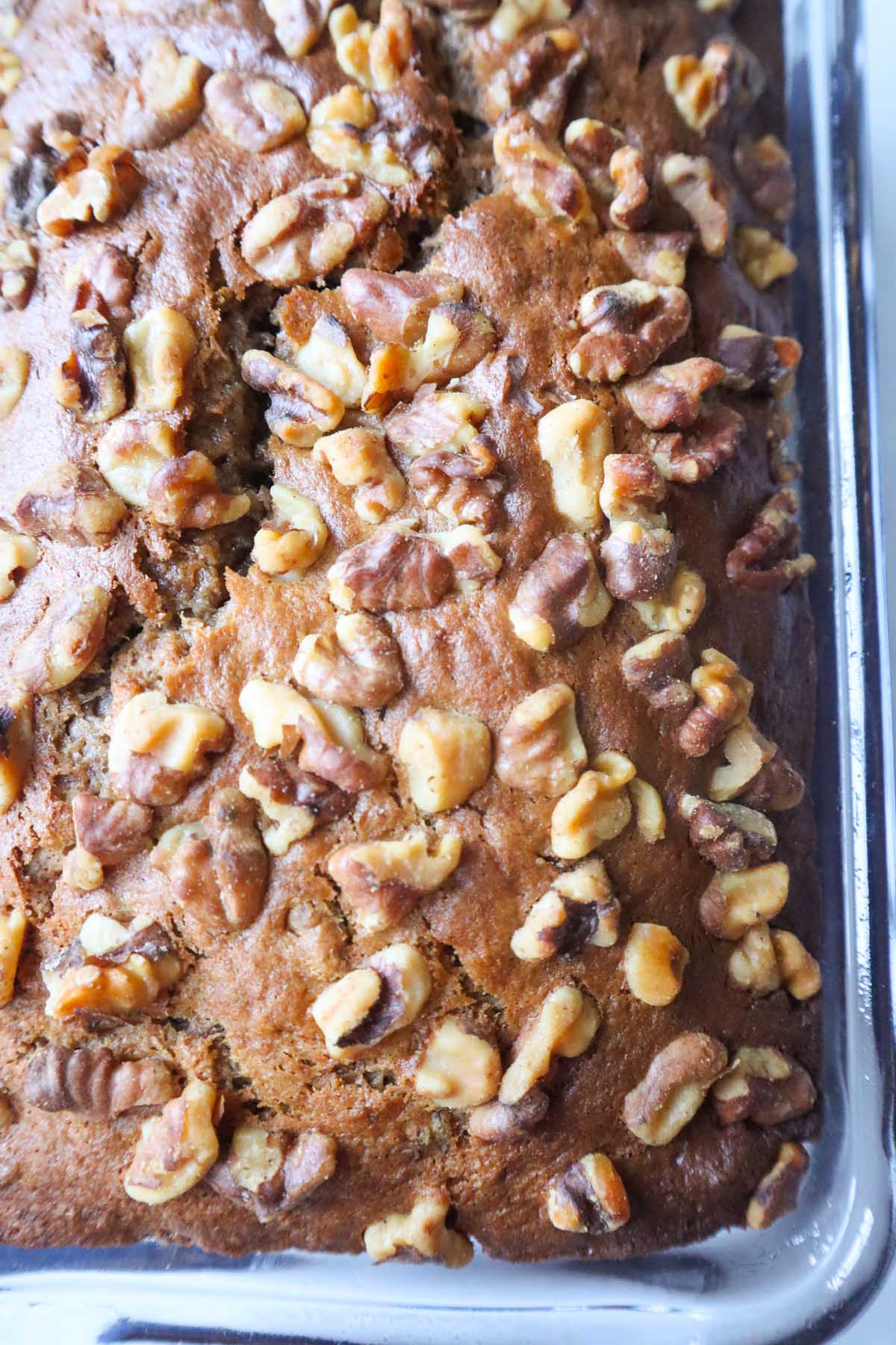 4 ingredient banana bread topped with walnuts in a glass baking dish