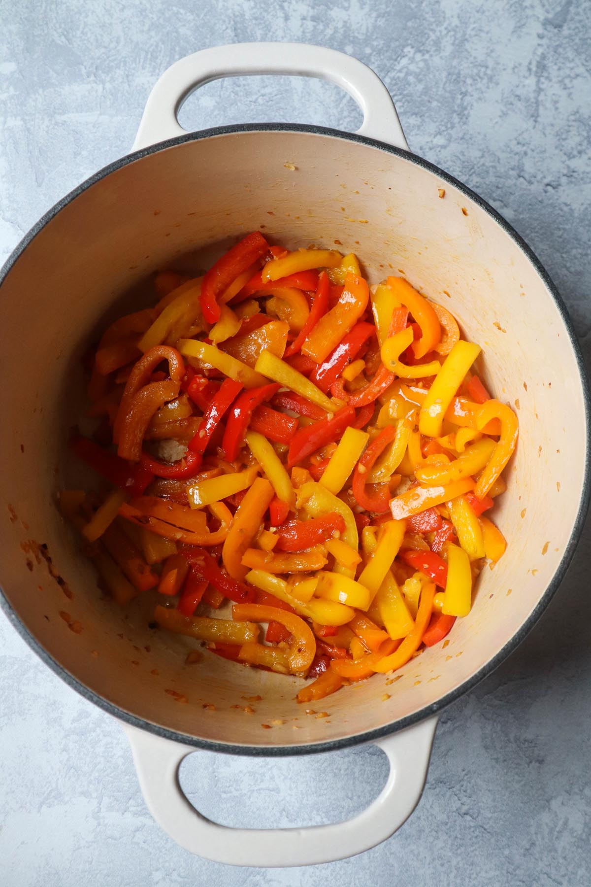 dutch oven with sautéed peppers and garlic
