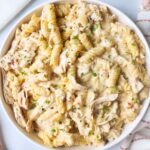 white bowl with garlic parmesan chicken pasta topped with fresh thyme