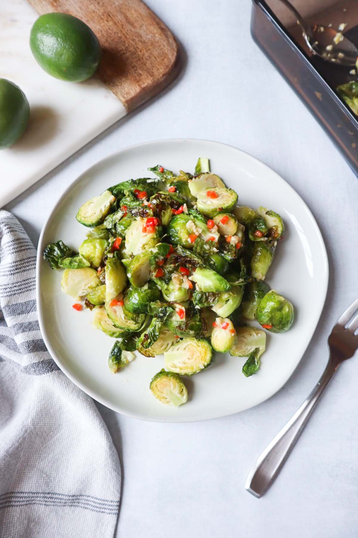 thai brussel sprouts with lime thai dressing on a white plate