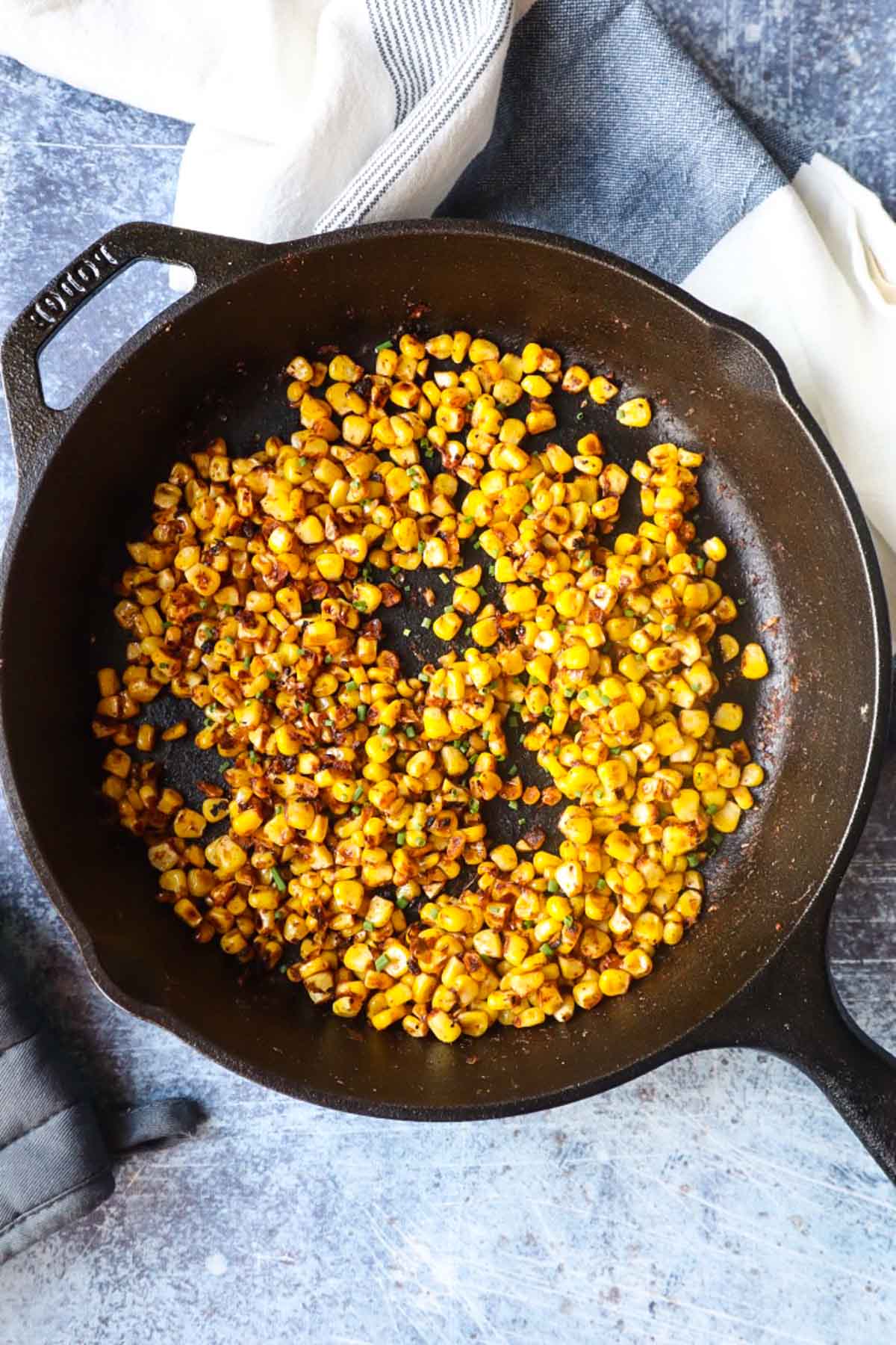 cast iron skillet with blackened corn and chives 