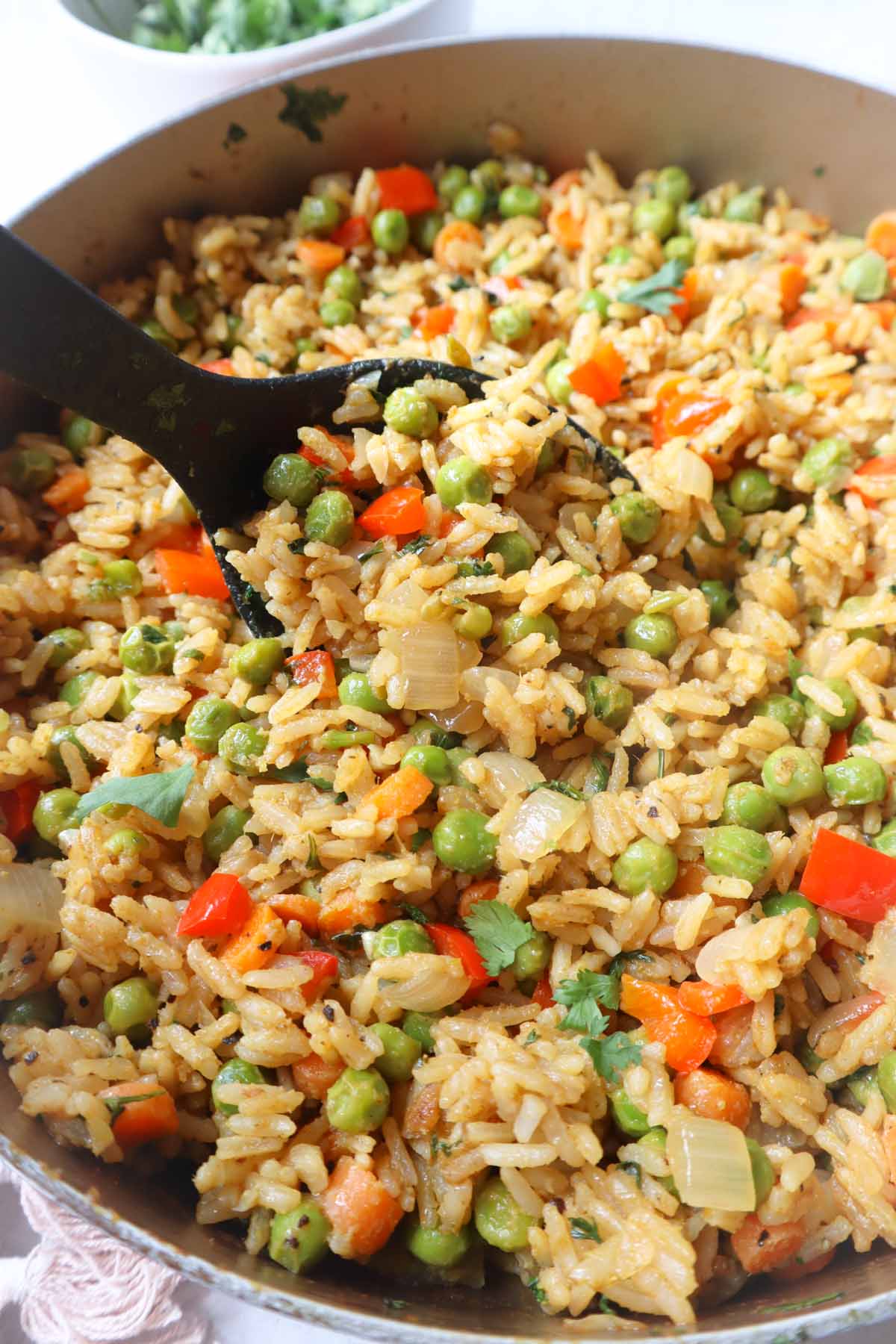 green curry fried rice in a large skillet with carrots, peas, and pepper