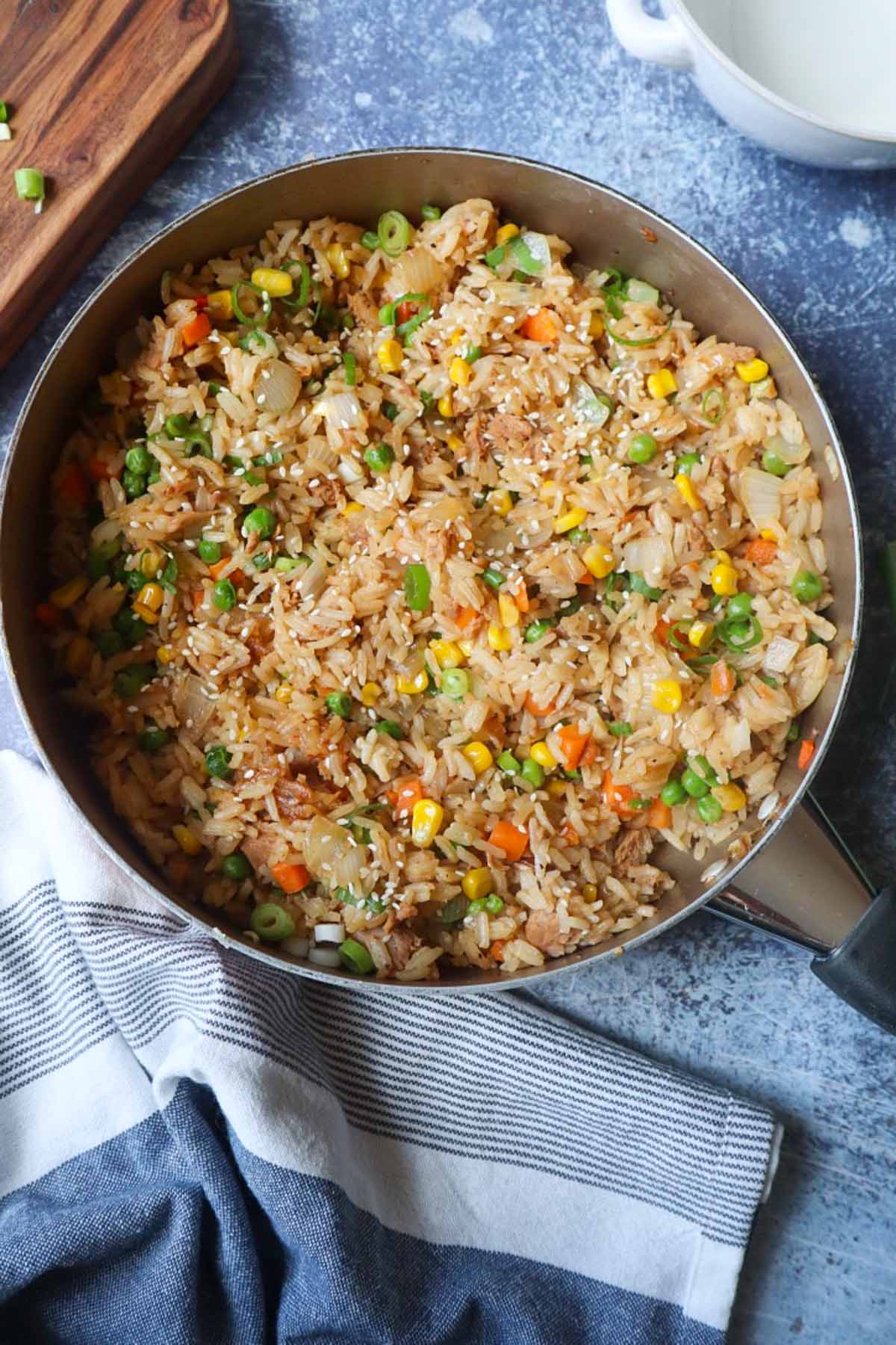 skillet with tuna fried rice with chopped vegetables and scallions