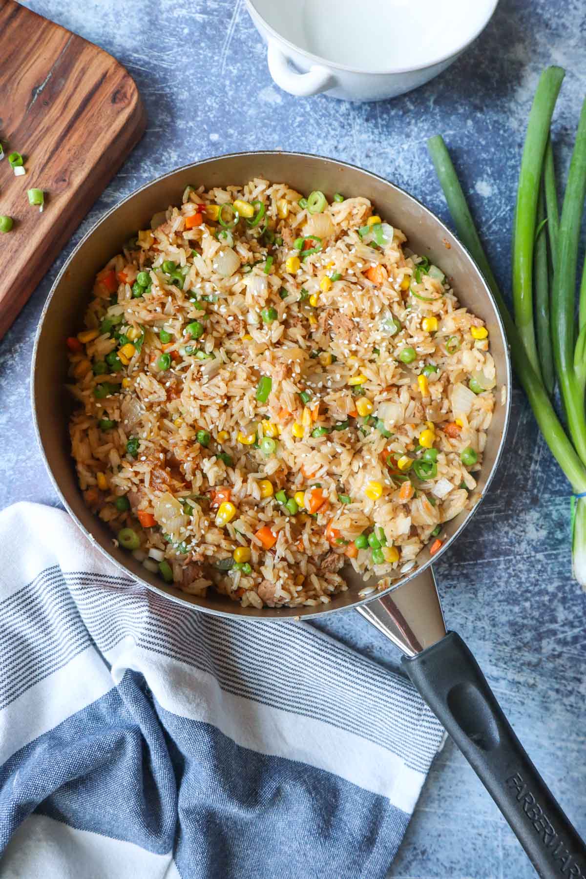 skillet with tuna fried rice with chopped vegetables and scallions