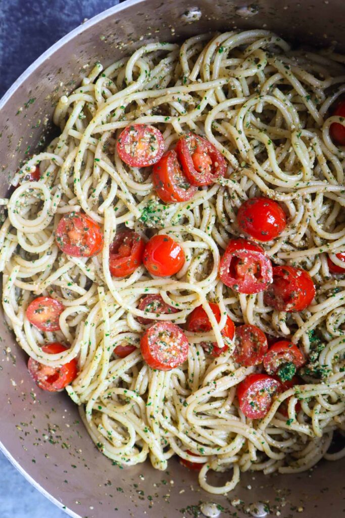 pot with spaghetti, pesto, and cherry tomatoes