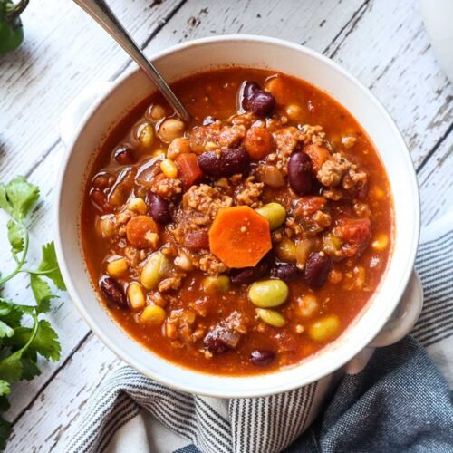 white bowl with panera turkey chili with kidney beans, edamame, carrots, and corn