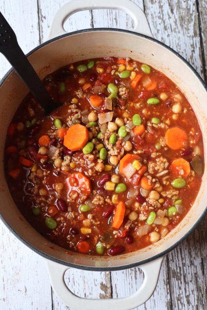 dutch oven with chili with carrots, edamame, beans, corn and more