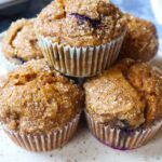 pumpkin blueberry muffins stacked and topped with turbinado sugar