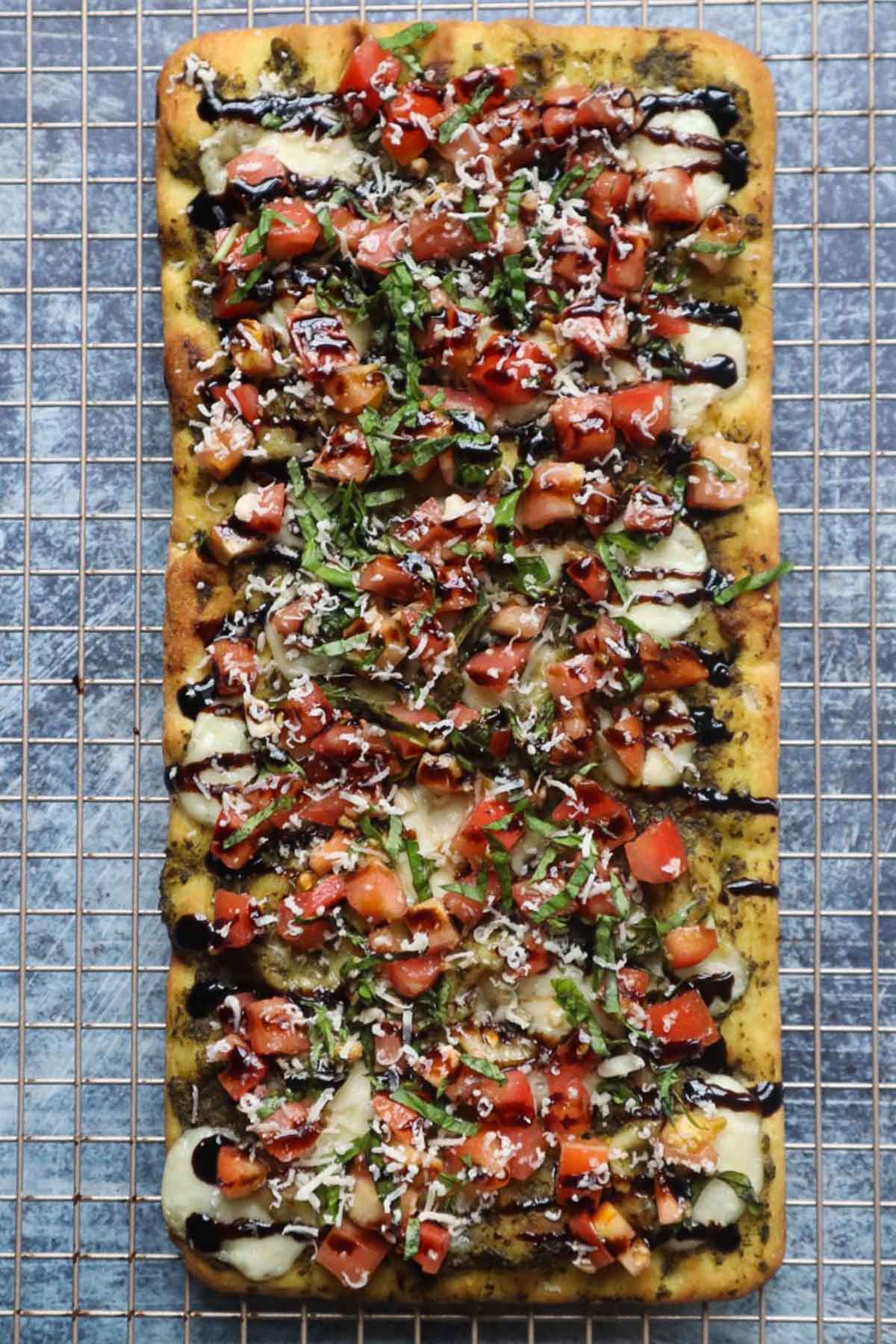 baking rack with bruschetta flatbread topped with cheese and balsamic glaze