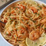 white bowl with linguine, shrimp, garlic, and lemon