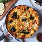 skillet with paella topped with shrimp and mussels