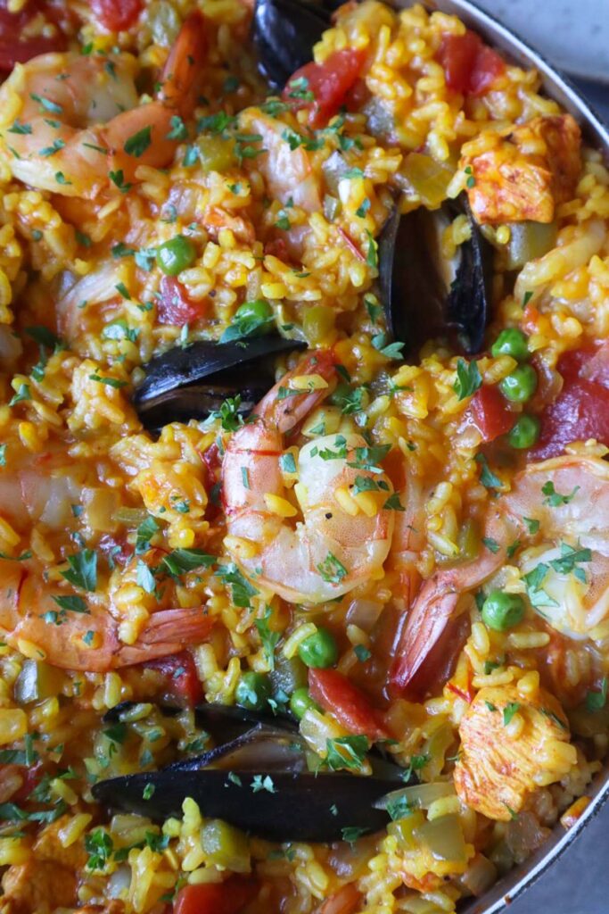 skillet with paella topped with shrimp and mussels