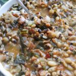 white bowl with spoon scooping up cooked black eyed peas.