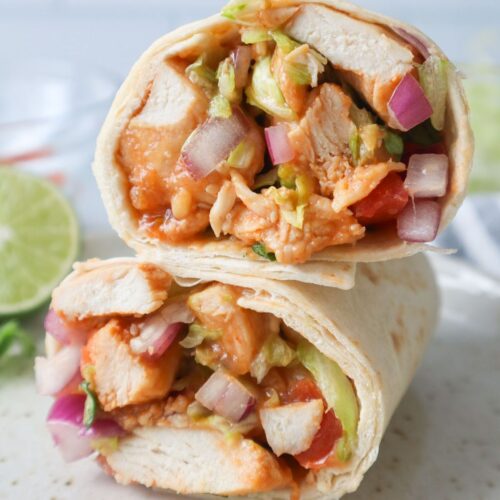 sriracha chicken wraps sliced and stacked on top of each other.