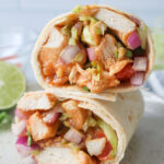 sriracha chicken wraps sliced and stacked on top of each other.