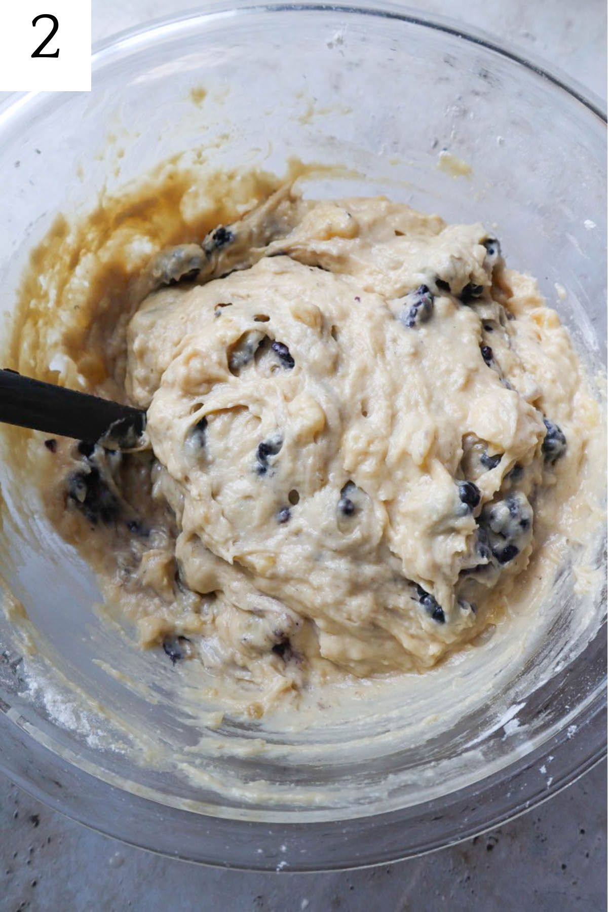 glass bowl with blackberries folded into the batter.