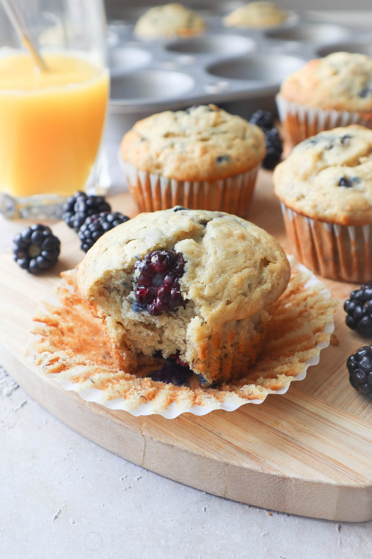 blackberry banana muffin with bite showing blackberry inside.