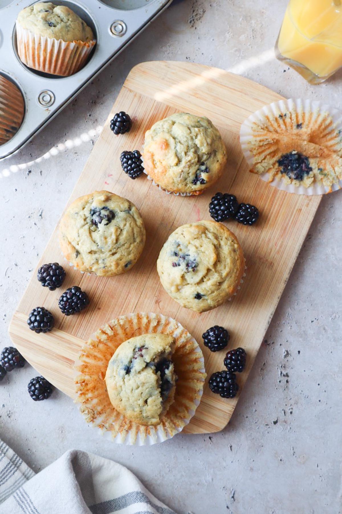 blackberry banana muffins on a cutting board.