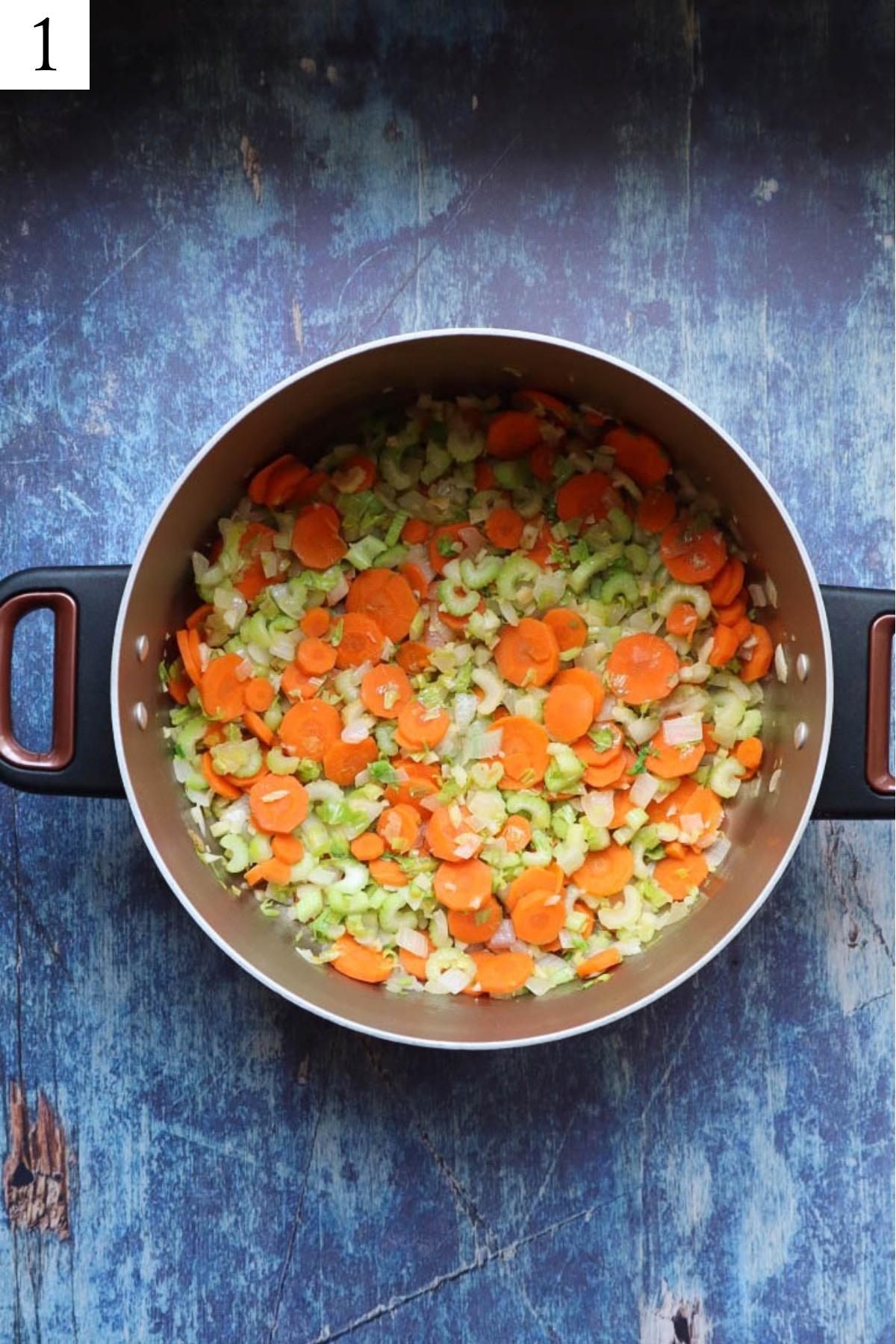 pot with sauteed carrots, celery, and onion.