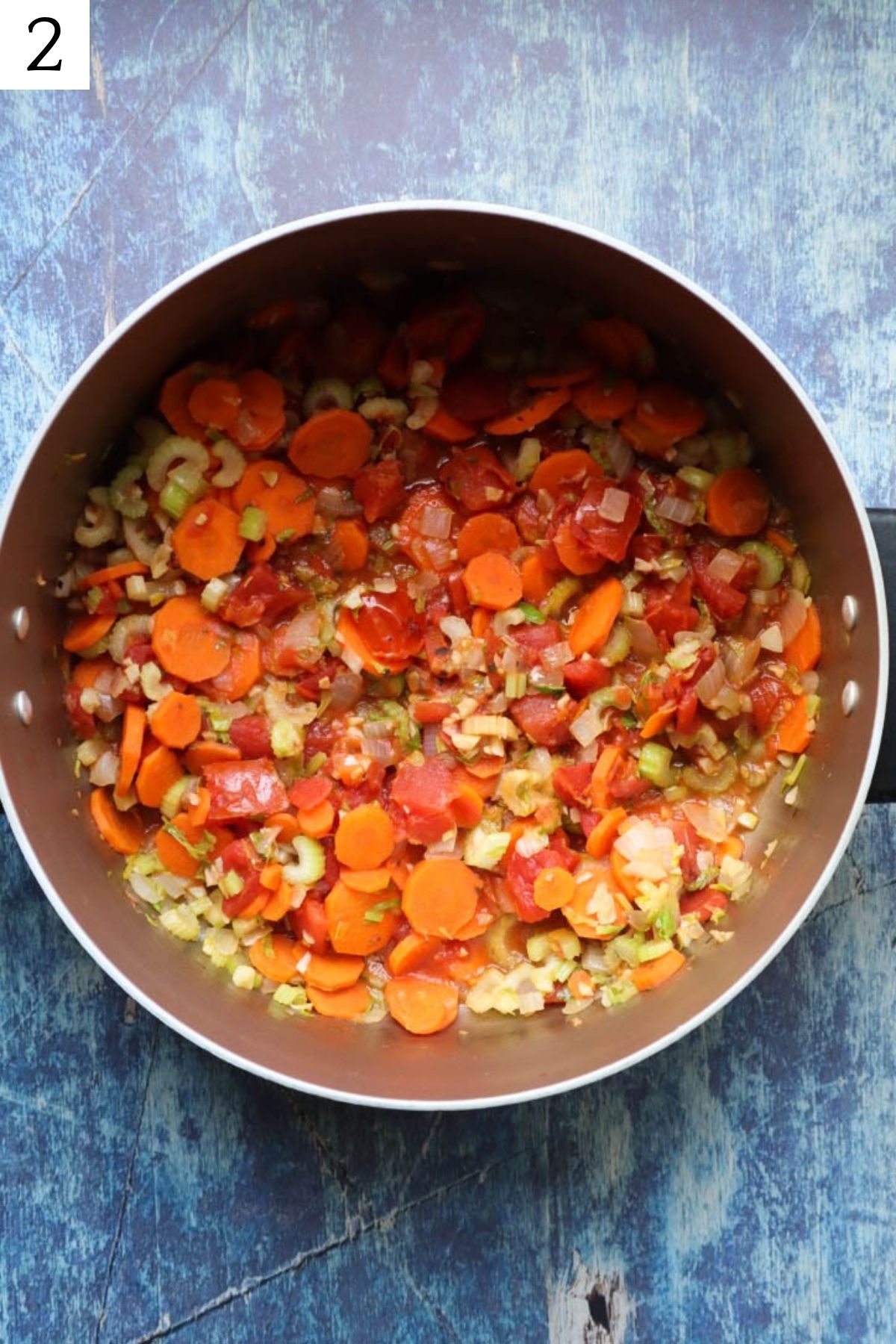 pot with sauteed vegetables and roasted tomatoes.