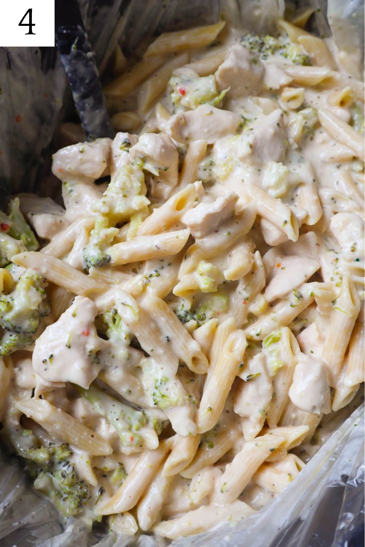 creamy chicken alfredo with broccoli in a slower cooker.