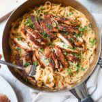 skillet with cajun chicken alfredo topped with parsley.