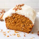 pumpkin bread topped with pecans and cream cheese frosting.