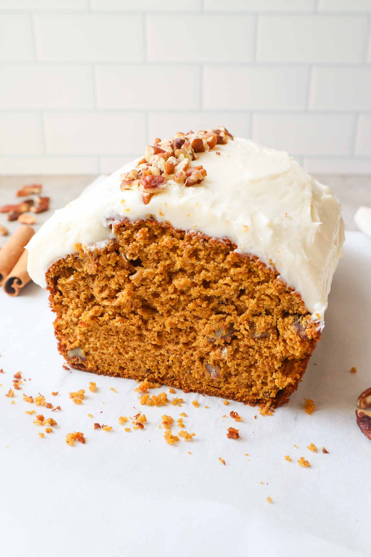 pumpkin bread topped with pecans and cream cheese frosting.
