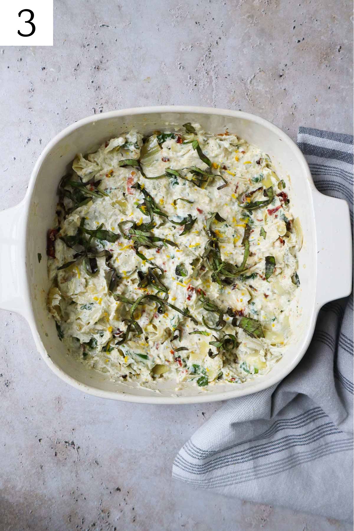 baking dish with boursin cheese dip topped with basil.