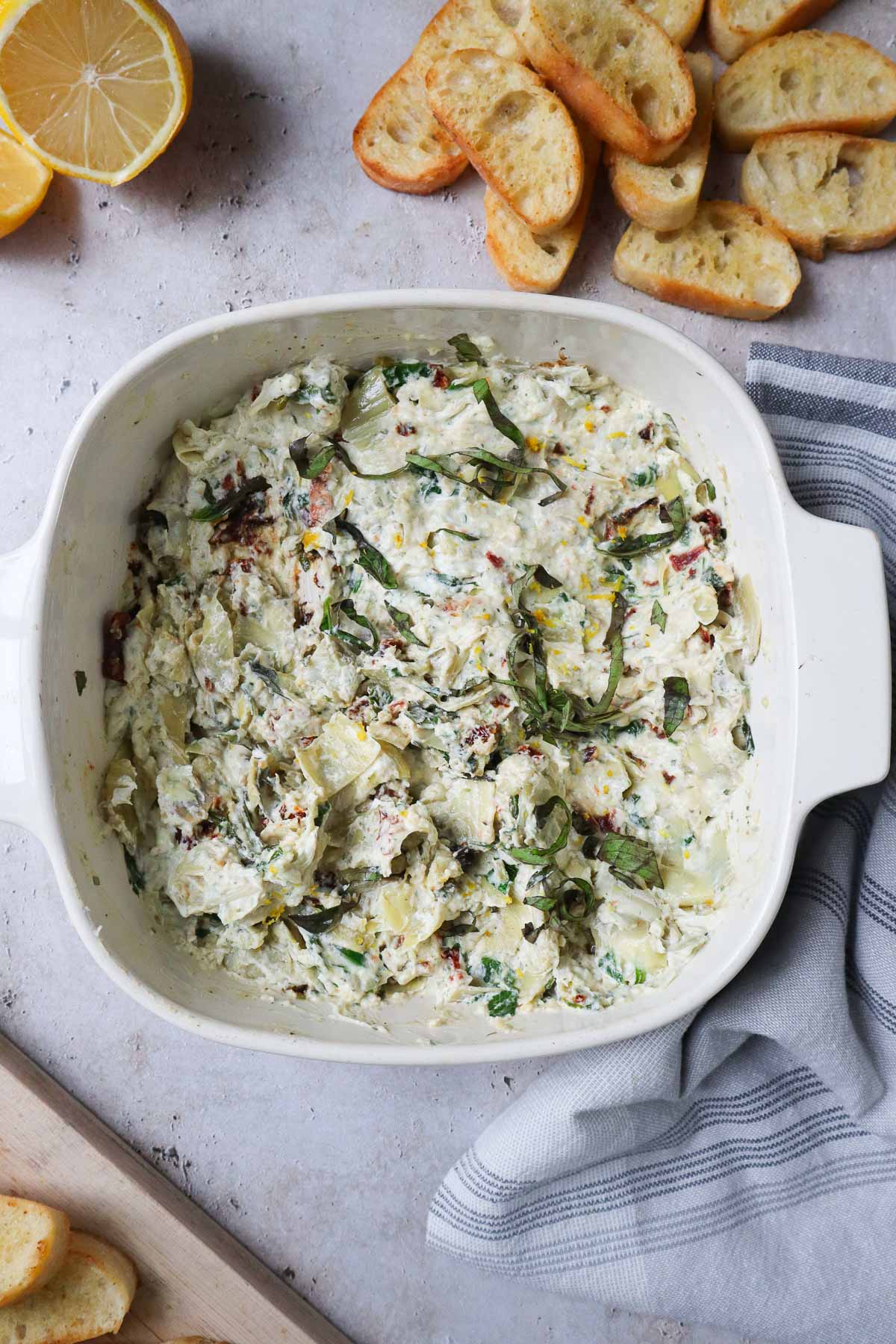 baking dish with creamy boursin cheese dip surrounded by crostinis.