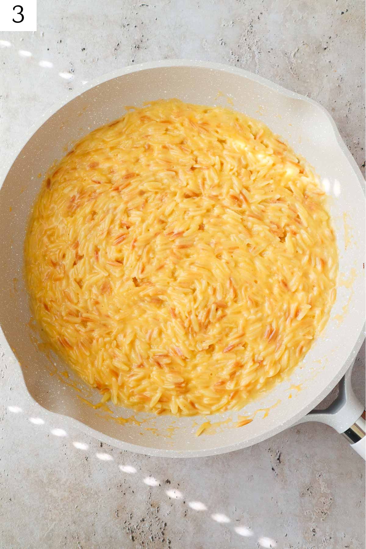 skillet with cheesy orzo.