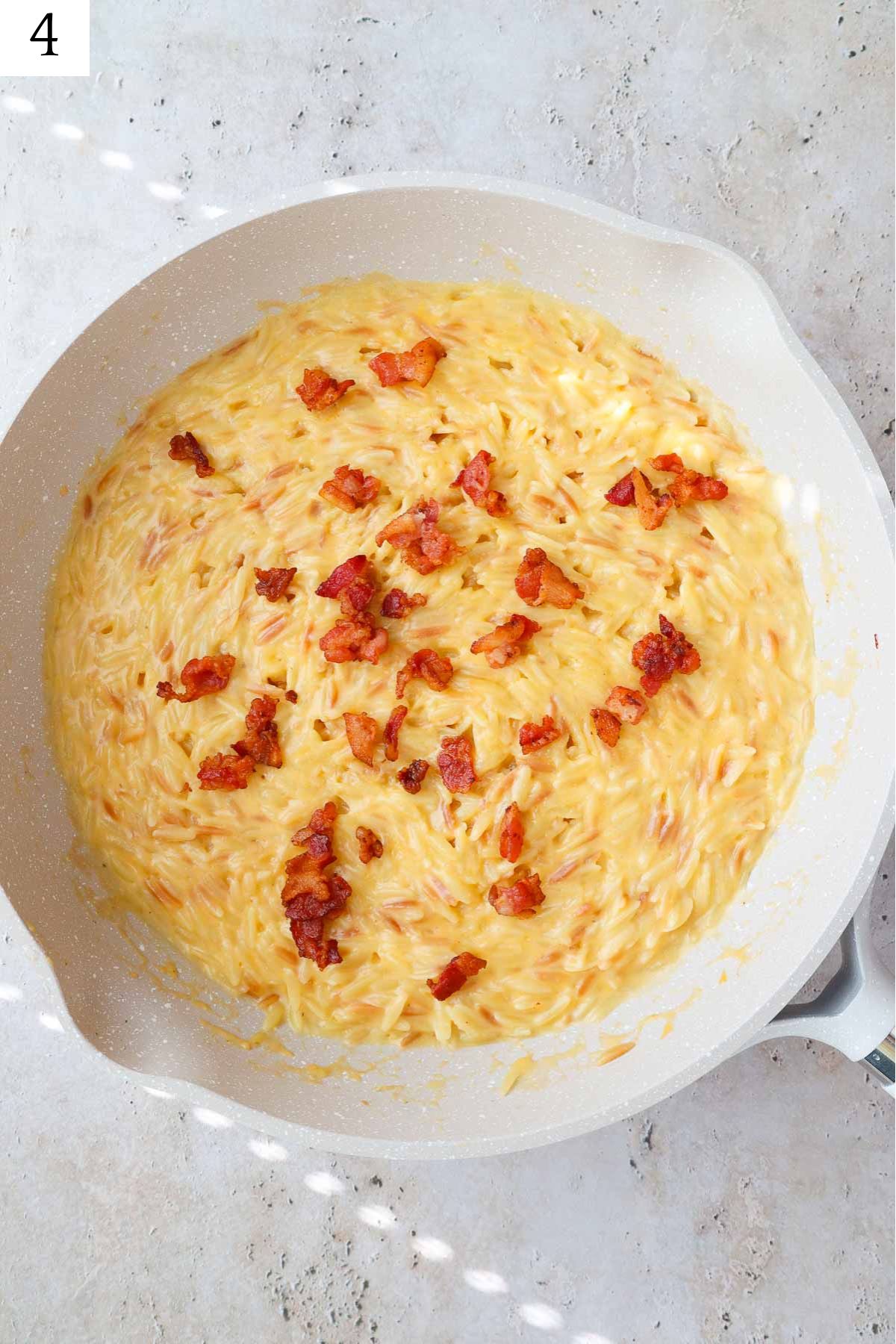 cheesy mac and cheese topped with bacon pieces.