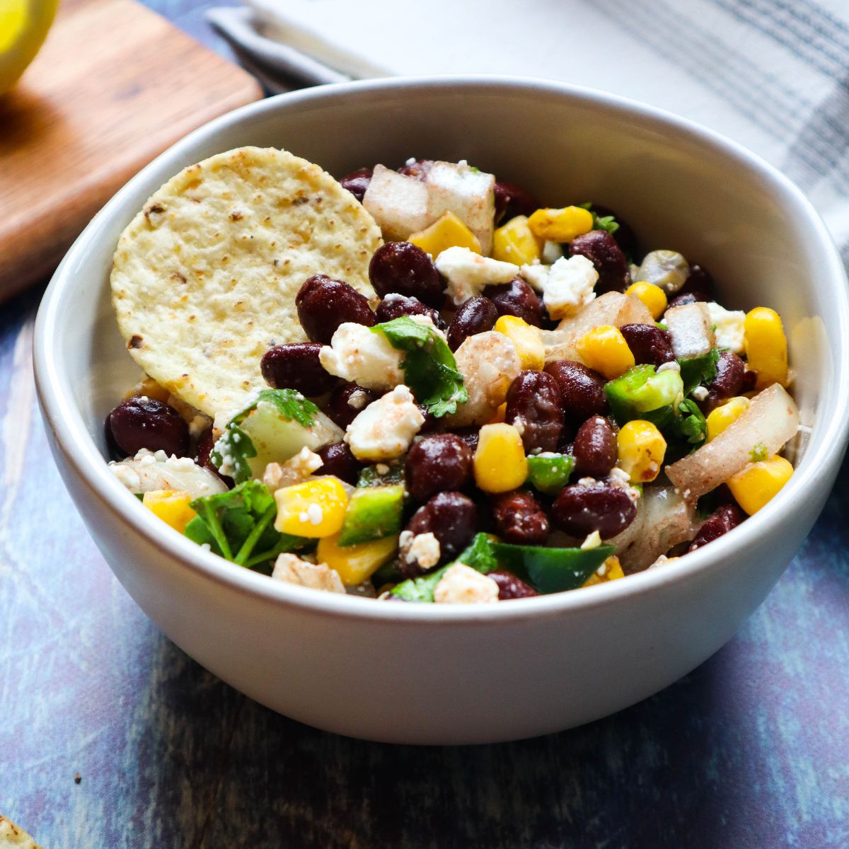 white bowl with black bean corn feta dip.