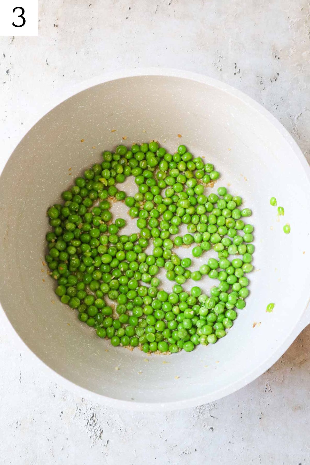 pot with peas, garlic, and olive oil.