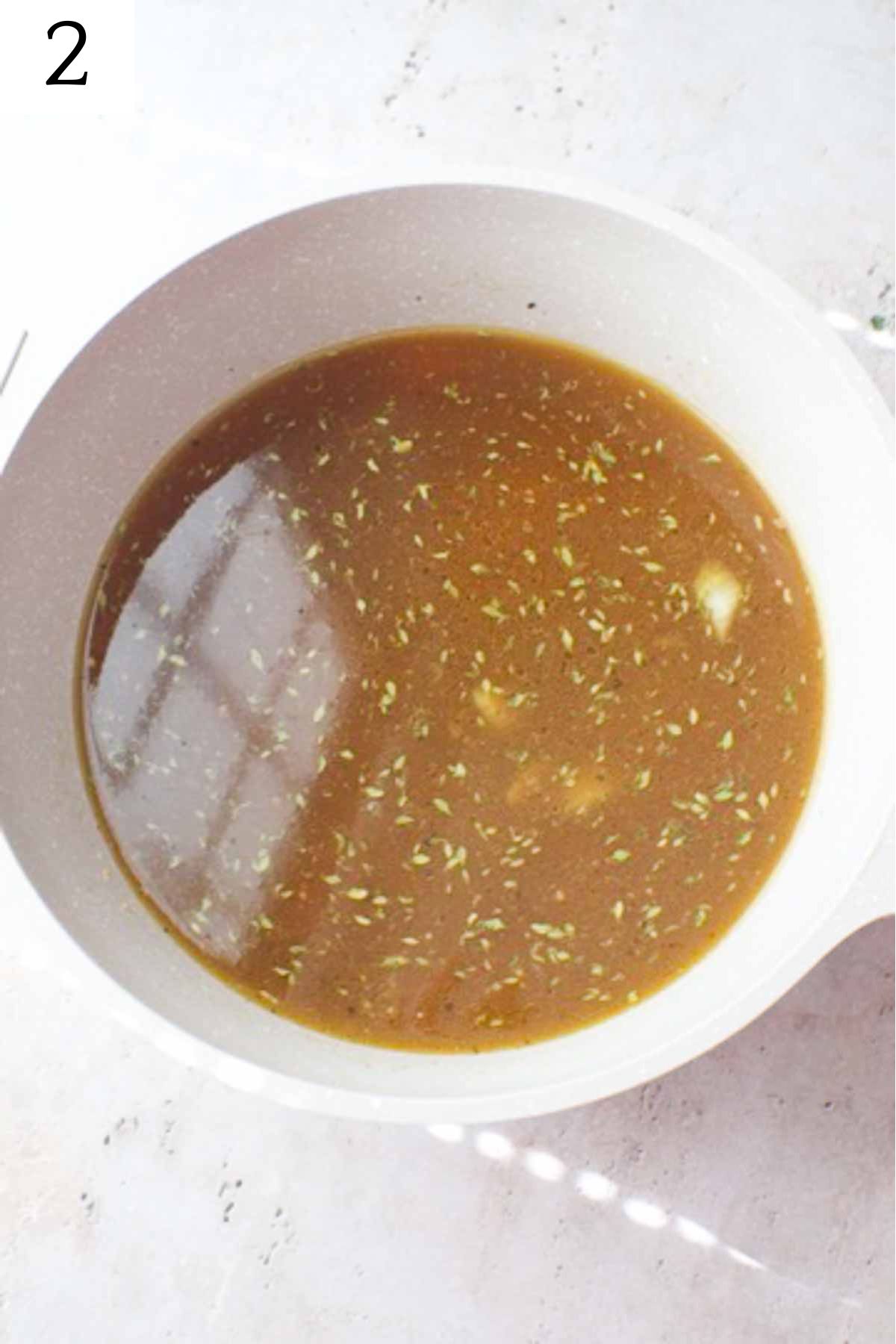 pot with broth, carrot, onion, and thyme.