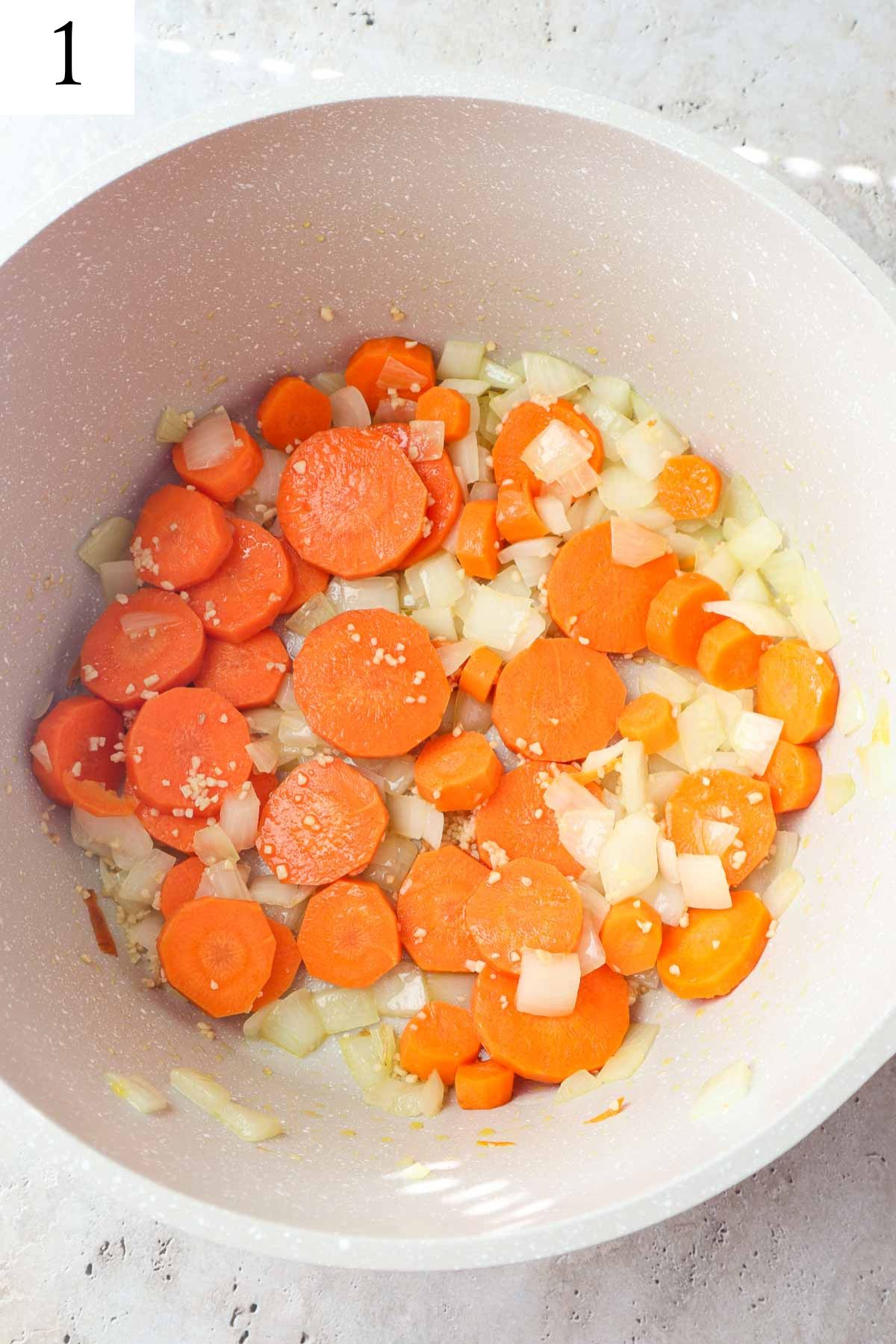 pot with sauteed carrots, onion, garlic in olive oil.