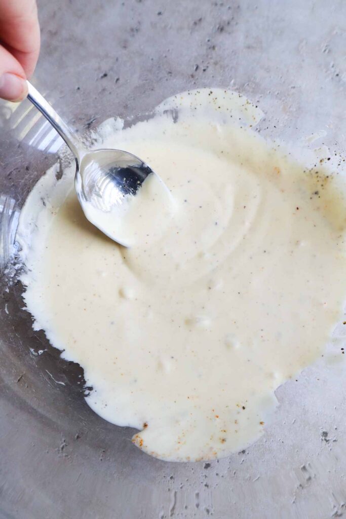 all ingredients for the dressing mixed together in a glass bowl.