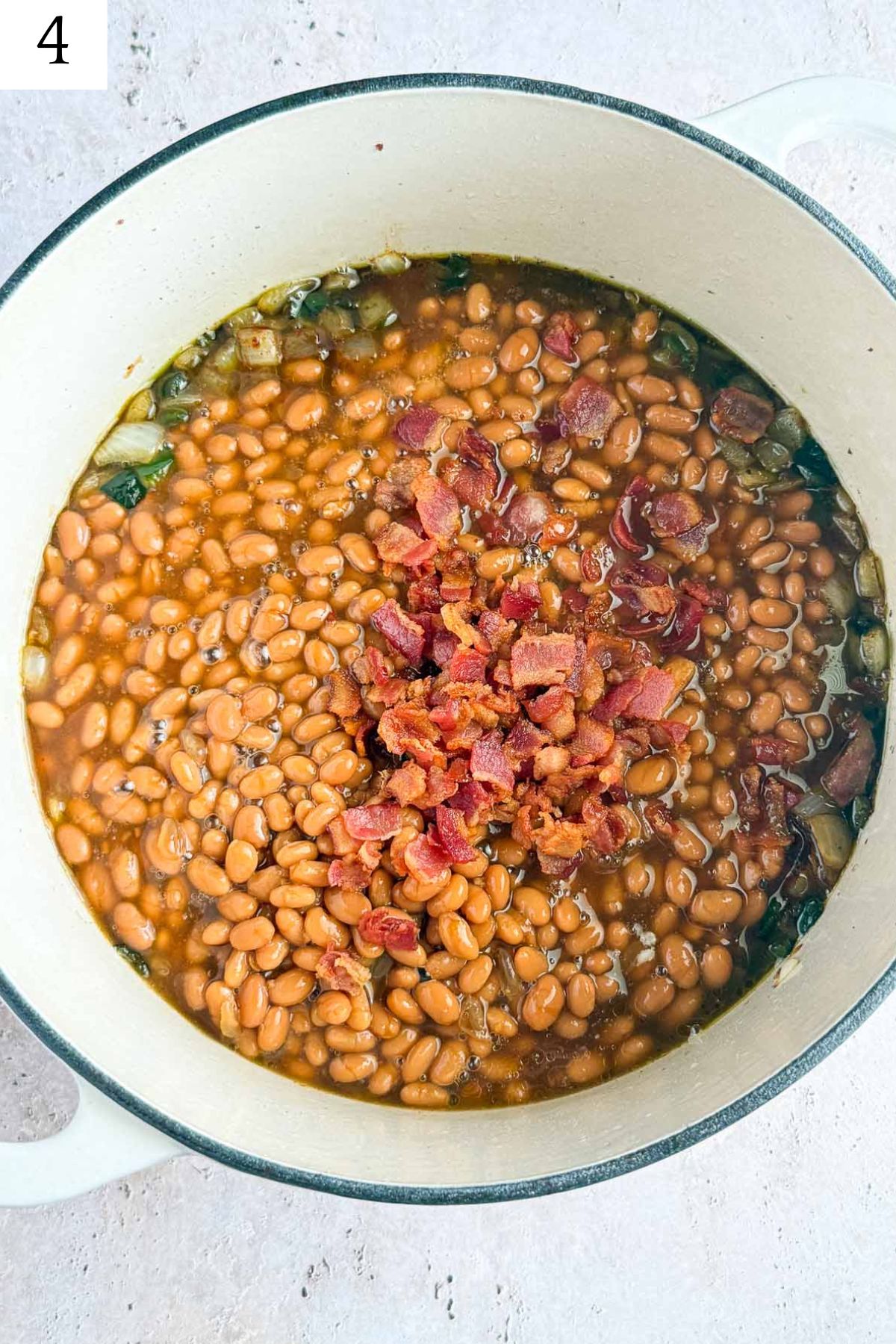 dutch oven with baked beans, onion, poblano, and crispy bacon.