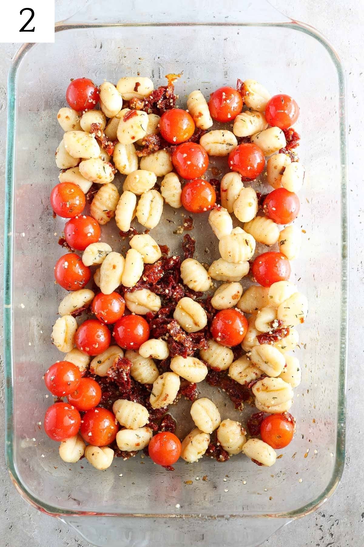 glass baking dish with gnocchi, tomatoes, and seasonings.